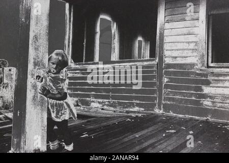 Fine seventies black and white extreme photography of a toddler standing on a porch Stock Photo