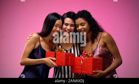 Women giving presents to friend and hugging, having fun at bridal shower, joy Stock Photo