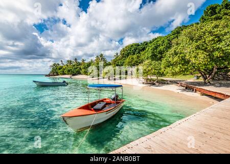 Small motorized boat at the pier and beach of Cayo Levantado Island, Samana Bay, Dominican Republic. Stock Photo