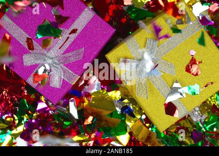 Colorful sparkling birthday or other concept presents in purple and yellow box with confetti top view background Stock Photo
