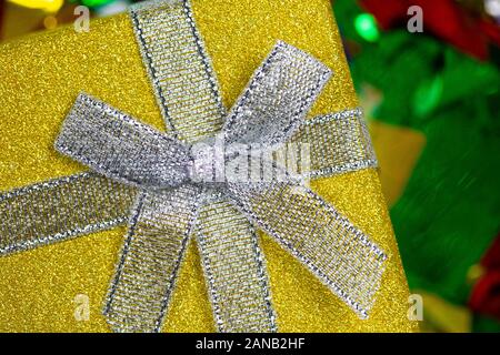 Colorful sparkling birthday or other concept presents in purple and yellow box with confetti top view background Stock Photo