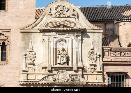 A statue of Pope Urban VIII sits above an elaborately decorated doorway to Iglesia de San Pedro in Plaza de San Pedro  Seville Stock Photo
