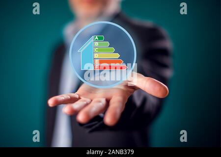 Businessman in suit showing open hand with virtual sign of energy rating. Energy saving and environment ptotection concept Stock Photo