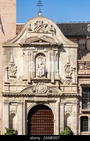 A statue of Pope Urban VIII sits above an elaborately decorated doorway to Iglesia de San Pedro in Plaza de San Pedro  Seville Stock Photo