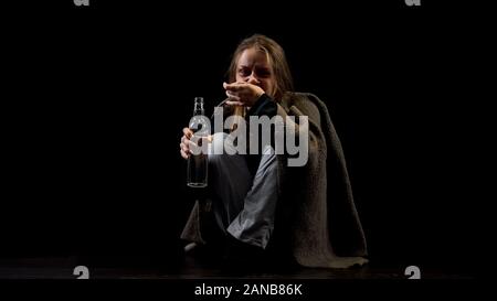 Depressed alcohol addicted woman drinking vodka from bottle, looking with hatred Stock Photo