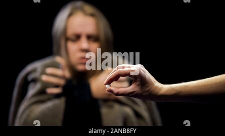 Hand offering ecstasy to woman suffering withdrawal symptoms, drug addiction
