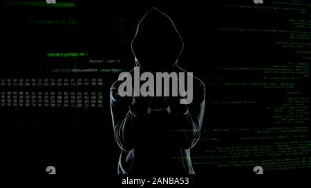 Silhouette of handcuffed angry hacker on animated computer code background Stock Photo