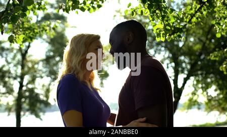 Cheerful mixed race couple looking at each other with love, happy to be together Stock Photo