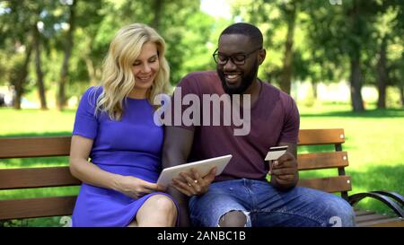 Couple booking tickets online using tablet, credit card payment, banking Stock Photo