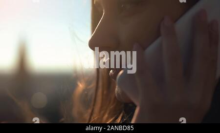 Pretty smiling lady talking cellphone with friend standing on skydeck connection Stock Photo