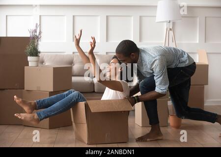 Excited laughing family couple playing in living room. Stock Photo