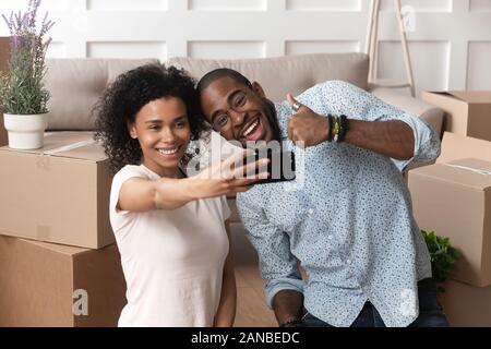Happy young family couple taking selfie photo in new apartment. Stock Photo