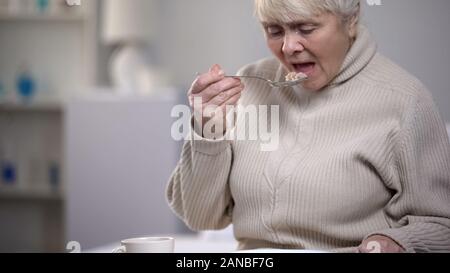Crying elderly lady eating dinner, suffering from loneliness in old age, closeup Stock Photo