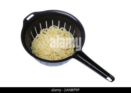Top view of a black plastic colander filled with spaghetti isolated on white background. Stock Photo