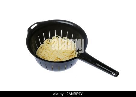 Black plastic colander filled with spaghetti isolated on white background. Stock Photo