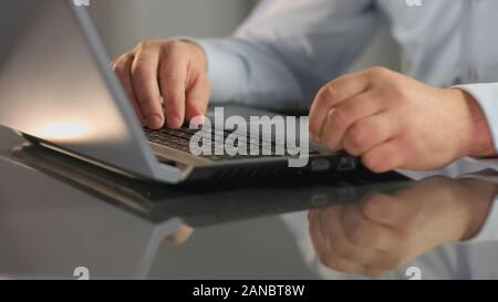 Manager working on laptop preparing report, analyzing information, internet Stock Photo