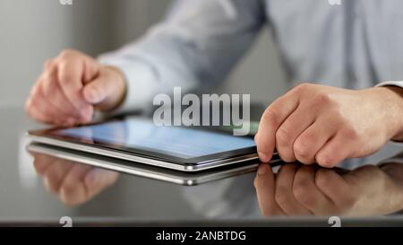 Company worker reading article on tablet, business application, news online Stock Photo