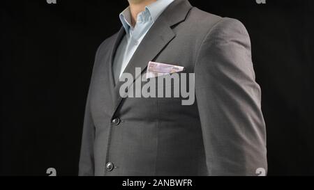 Euros in businessman suit pocket, money saving, income and successful startup Stock Photo