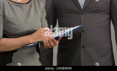Female worker making notes on financial chart, meeting with male boss, report Stock Photo
