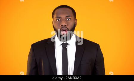 Shocked black businessman looking to camera, overwhelming proposition, surprise Stock Photo