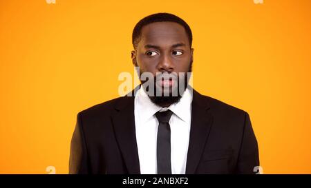 Doubtful afro-american male in formalwear looking suspiciously aside uncertainty Stock Photo