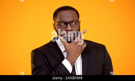 Suspicious african-american businessman in glasses considering options, dilemma Stock Photo