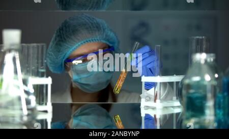 Scientist analyzing meat sample in preservative agent, food quality research Stock Photo