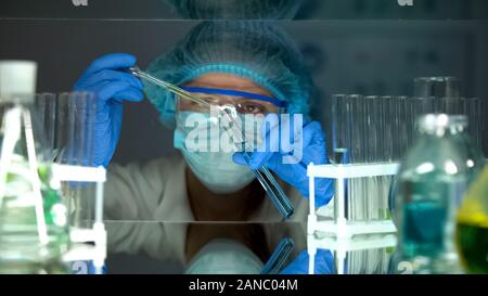 Researcher pouring green substance in blue liquid, checking water sediments Stock Photo