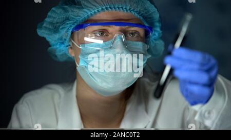 Scientist checking oil in tube, studying thermal capacity, research development Stock Photo