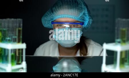 Upset lab worker in protective glasses and uniform after faulty experiment Stock Photo