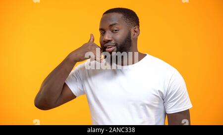 Handsome Afro-American man showing call me gesture, customer services, feed back Stock Photo