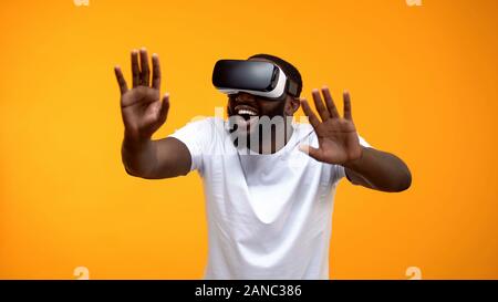 Happy African-American man using VR headset exploring future technologies Stock Photo