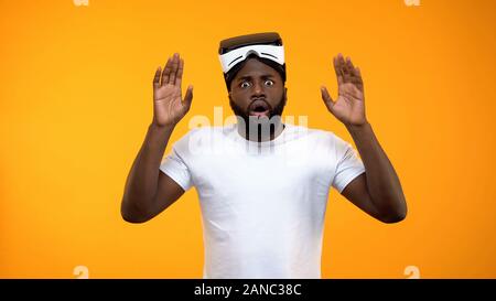 Shocked Afro-American man amazed of virtual reality simulation, modern gadget Stock Photo