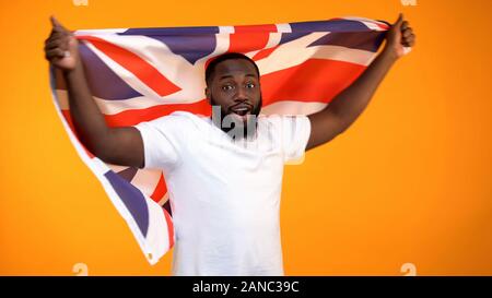 Afro-American man holding British flag, supporting election winner, politic Stock Photo