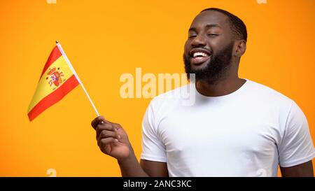 Afro-American man holding Spain flag, political support, international relations Stock Photo