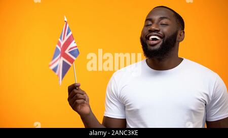 Black man holding British flag, international friendship, political support Stock Photo