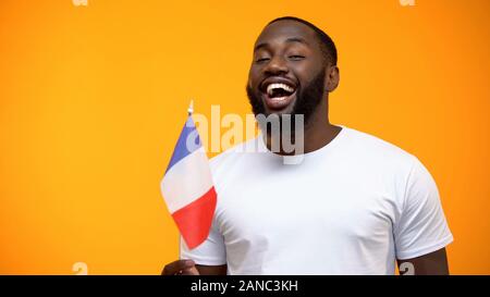 Afro-American man holding French flag on national holiday celebration, close-up Stock Photo