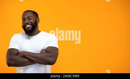 Handsome Afro-American man standing with hands crossed, looking at camera Stock Photo
