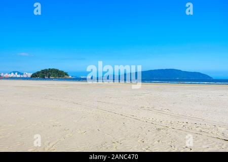 Brazilian Paulista beach with a huge band of waterfront sand on beautiful day. Photo at Itarare beach, Sao Vicente city with the view to Santos SP cit Stock Photo