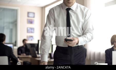 Angry businessman holding cellphone, worrying about problems at work, overwork Stock Photo