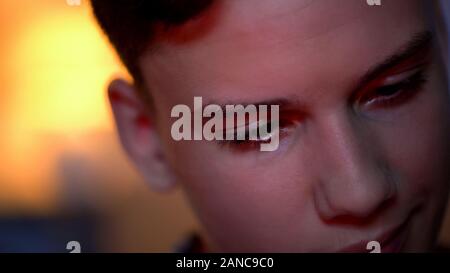 Teenage boy playing computer games, harmful influence on state of mind, close-up Stock Photo