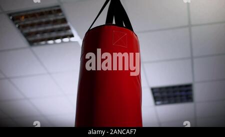 Punching bag under ceiling in office, overcoming business difficulties concept Stock Photo
