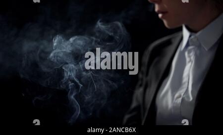 Businesswoman in smoke isolated on dark background, air pollution, closeup Stock Photo