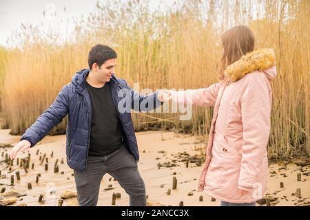 a young couple romps happily around on a beach Stock Photo
