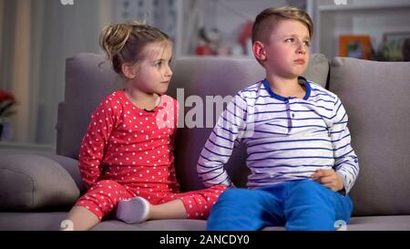 Children caught by parents, watching TV at night instead of sleeping, leisure Stock Photo