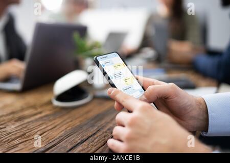 Distracted Businessman Using Mobile Phone In Meeting Stock Photo