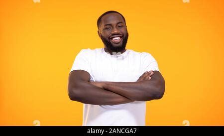 Smiling black male folded arms looking camera bright background, positive mood Stock Photo
