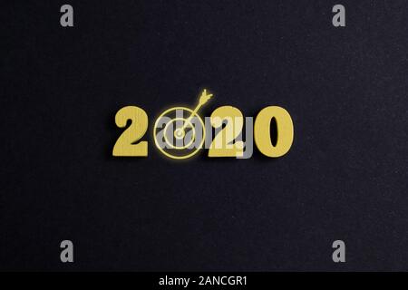 The concept of achieving the goals in 2020. Wooden figures on a black background. Close up. Top view. Stock Photo