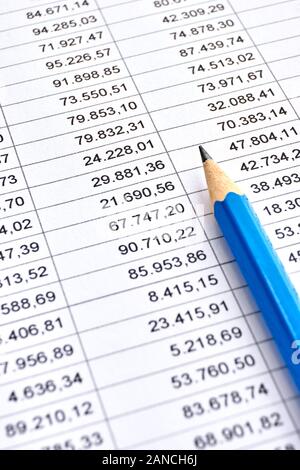 Blue pencil on a sheet of white paper with printed financial numerical data table with columns. Accounting, budget, profit, tax and finance concept. Stock Photo