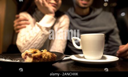 Old friends sitting in cafe, hugging and talking, warm relationship, close up Stock Photo